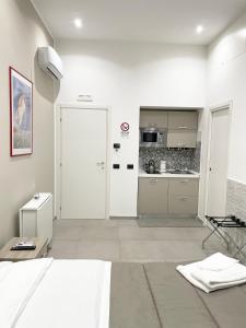 um quarto branco com uma cama e uma cozinha em Room25mq em Cercola