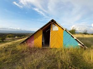eine bunte Hütte auf einem Feld mit hohen Gras in der Unterkunft Mirador Valle de la Tatacoa in Villavieja
