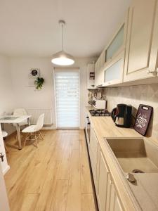 eine Küche mit weißen Schränken, einem Tisch und einem Esszimmer in der Unterkunft Maxx Suites Cluj Napoca in Cluj-Napoca