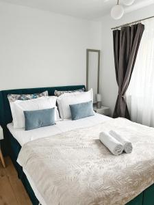 ein Schlafzimmer mit einem großen Bett mit zwei Handtüchern darauf in der Unterkunft Maxx Suites Cluj Napoca in Cluj-Napoca