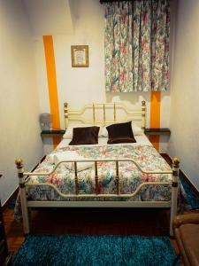 ein Schlafzimmer mit einem großen Bett mit einer bunten Decke in der Unterkunft Abrigo da Estrela in Covilhã