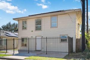 a house with a fence in front of it at Stunning & Vibrant APT 7 Min From TX Med Center in Houston