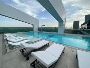 a pool on top of a building with tables and chairs at Feel home ! Away from home in Dubai