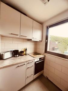 a small kitchen with white cabinets and a window at Ferienwohung Arnstein Nr 2 in Waldeck