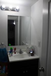 a bathroom with a sink and a mirror at Victoriaville Suite in Brampton