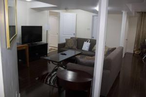 a living room with a couch and a table at Victoriaville Suite in Brampton