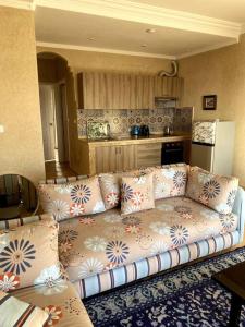 een woonkamer met een bank en een keuken bij A6 MAISON BLANCHE IMI OUADDAR in Agadir