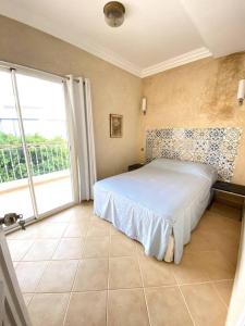 een slaapkamer met een bed en een groot raam bij A6 MAISON BLANCHE IMI OUADDAR in Agadir