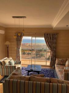 een woonkamer met een bank en een groot raam bij A6 MAISON BLANCHE IMI OUADDAR in Agadir