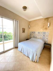 een slaapkamer met een bed en een groot raam bij A6 MAISON BLANCHE IMI OUADDAR in Agadir