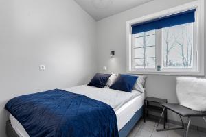1 dormitorio con 1 cama, 1 silla y 1 ventana en Iceland Inn Lodge, entire place with hot tub., en Selfoss