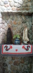 stół z figurkami na kamiennej ścianie w obiekcie Pousada Ribeirinha w mieście Aparecida