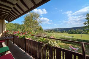 a balcony with a view of a field and trees at Ferienwohnung Panoramablick Freudenstadt in Freudenstadt