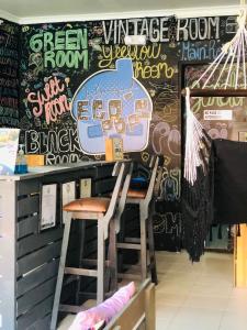 a bar with two stools and a wall covered in graffiti at Casa Egos Pop Laureles in Medellín