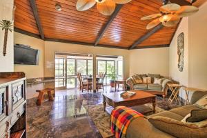 Kailua-Kona Home with Tropical Bar Walk to Beach! في كيلوا كونا: غرفة معيشة مع أريكة وطاولة