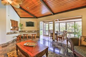 Kailua-Kona Home with Tropical Bar Walk to Beach! في كيلوا كونا: غرفة معيشة مع أريكة وطاولة