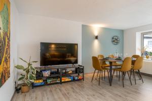 ein Esszimmer mit einem Tisch und einem TV in der Unterkunft FREERIDE - 7min to Greenhill, PS4, BBQ, Terrace, SSC in Schmallenberg