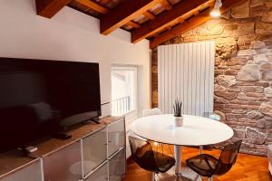 sala de estar con mesa y TV grande en Private Luxury, en Udine