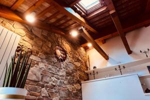 a kitchen with a stone wall and a refrigerator at Private Luxury in Udine +21 photos