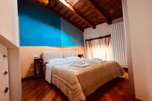 1 dormitorio con 1 cama grande y pared azul en Private Luxury, en Udine