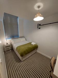 sypialnia z łóżkiem z zielonym kocem w obiekcie bankwellstreet w Manchesterze
