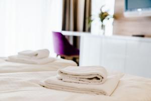 a stack of towels sitting on top of a bed at Appartements Am Kranichsee in Hahnenklee-Bockswiese +27 photos