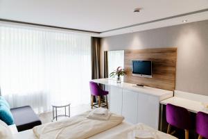 a hotel room with a bed and a tv at Appartements Am Kranichsee in Hahnenklee-Bockswiese
