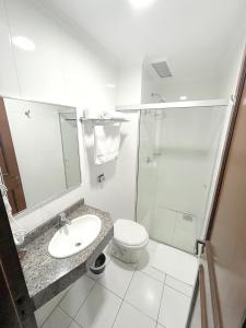 a bathroom with a toilet and a sink and a shower at Hotel Ijuí in Ijuí