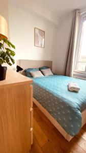 1 dormitorio con 1 cama en una habitación con ventana en Appartement 2 pièces à quelques minutes de Paris en Le Pré-Saint-Gervais