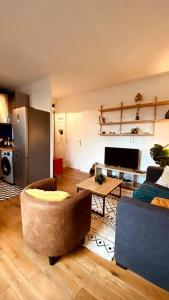 Appartement 2 pièces à quelques minutes de Paris في Le Pré-Saint-Gervais: غرفة معيشة مع أريكة وطاولة