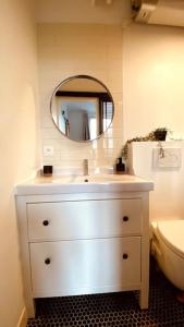 y baño con lavabo blanco y espejo. en Appartement 2 pièces à quelques minutes de Paris en Le Pré-Saint-Gervais