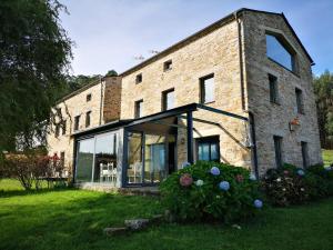 a brick building with large windows and a yard at Casas Do Consul - Mar y Montaña in O Vicedo