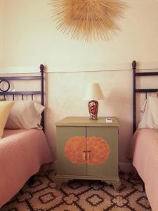 a bedroom with two beds and a table with a lamp at Casa Miraflores in Seville