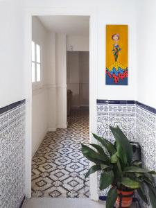 a hallway with a potted plant and a painting on the wall at Casa Miraflores in Seville