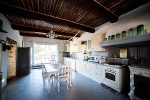 a kitchen with a table and a kitchen with white appliances at Gîte L'Olivier - La Roseraie du Val'Ensoleillé in Valensole