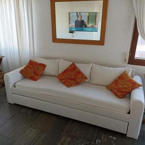 1 sofá blanco con 4 almohadas en la sala de estar en Frente a playa brava, en Punta del Este