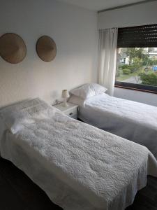 2 camas en una habitación de hotel con ventana en Frente a playa brava, en Punta del Este
