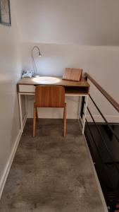 a desk with a chair and a lamp on it at Værelse, tv-stue og spiserum uden vand, ikke køkken, på første sal , eget badeværelse i stueetagen in Kværndrup