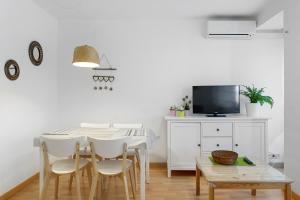 uma sala de jantar com mesa e cadeiras e uma televisão em Hauzify I Apartament Torremar em Torredembarra