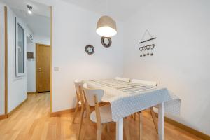 uma sala de jantar branca com uma mesa e cadeiras em Hauzify I Apartament Torremar em Torredembarra