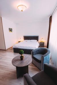 ein Schlafzimmer mit einem Bett, einem Sofa und einem Tisch in der Unterkunft Motel Piatra Corbului in Bicaz
