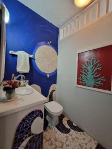 Baño azul con aseo y lavamanos en Casa decorada perto da Praia de Perequê - Ilhabela, en Ilhabela