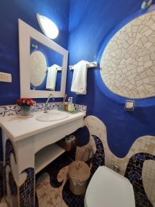Baño azul con lavabo y aseo en Casa decorada perto da Praia de Perequê - Ilhabela, en Ilhabela