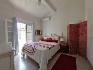 1 dormitorio con cama y ventana grande en Casa decorada perto da Praia de Perequê - Ilhabela, en Ilhabela