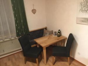 Un comedor con una mesa y dos sillas. en Ferienwohnungen Aigner, en Haus im Ennstal