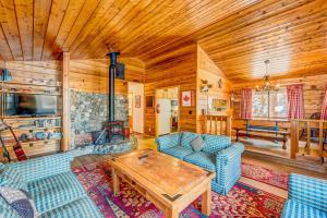 a living room with blue couches and a wooden ceiling at Ford Family Escape in Truckee