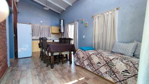 1 dormitorio con cama, mesa y cocina en Cabañas Laureano AJ en Cacheuta