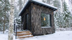 a small log cabin in the woods in the snow at Venejoen Piilo - Päre in Kontiolahti