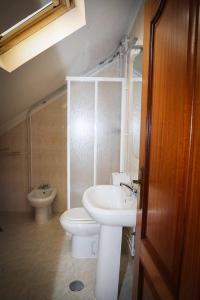 La salle de bains est pourvue d'un lavabo blanc et de toilettes. dans l'établissement Casa Fundo de Vila, à Manteigas