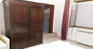 a wooden cabinet in a living room with a window at Le Due Palme in Marsala